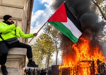 Protester with Palestinian Flag Amid Flames